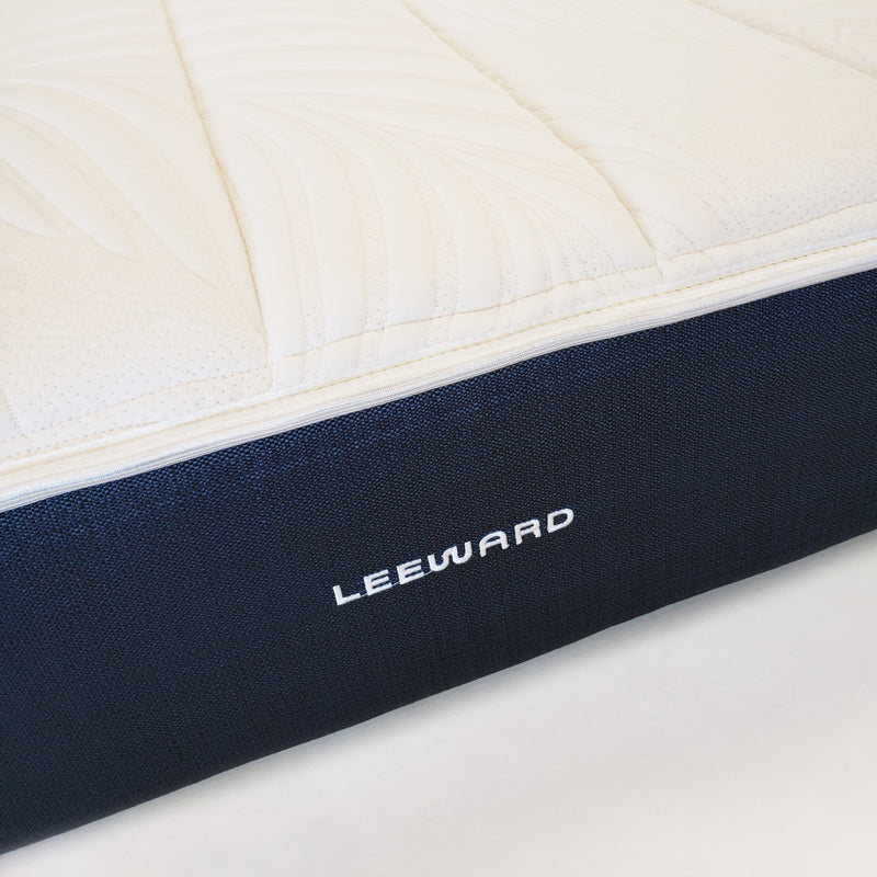 Close-up of a mattress with 'Leeward' branding on a white background